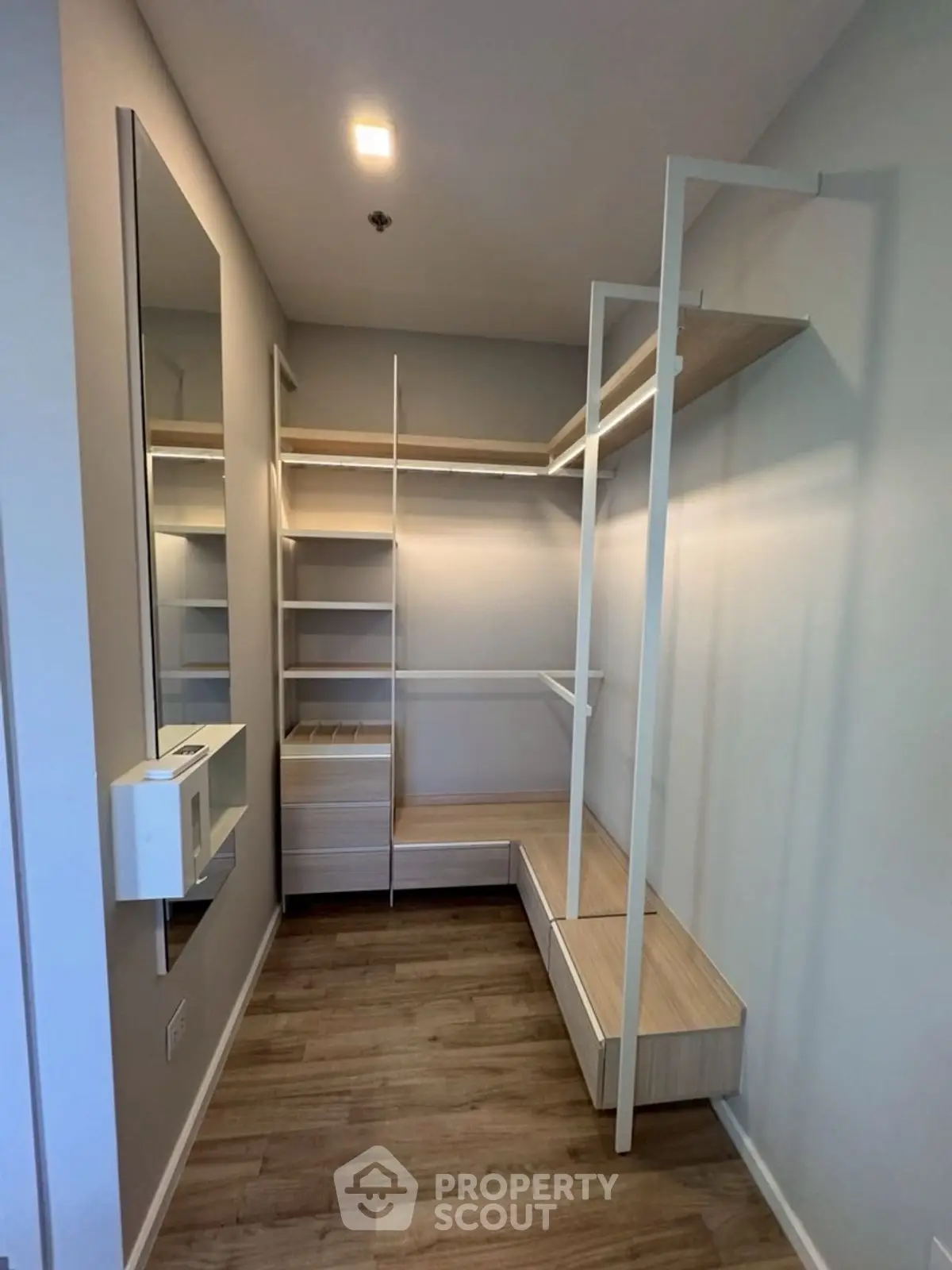 Spacious walk-in closet with modern shelving and wooden flooring