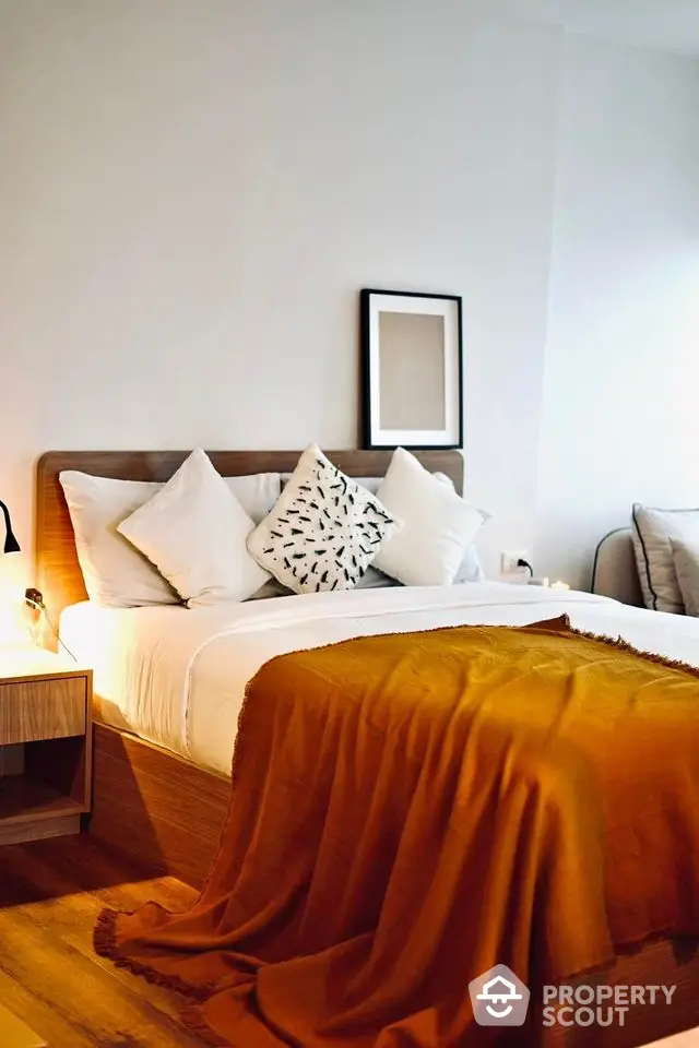 Cozy bedroom with modern decor and warm lighting, featuring a stylish bed and elegant furnishings.