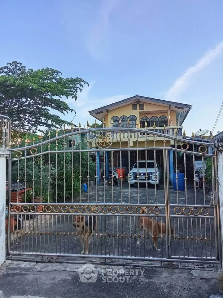 Charming two-story house with gated entrance and spacious driveway, perfect for family living.