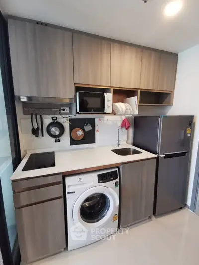 Modern compact kitchen with washing machine and sleek appliances