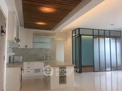 Modern kitchen with open layout and stylish ceiling design in a contemporary apartment.