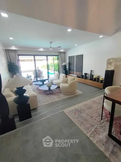 Luxurious living room with modern decor and pool view, perfect for relaxation and entertaining.