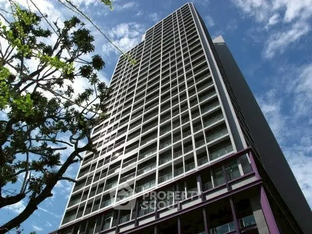 Modern high-rise building with sleek architecture against a clear blue sky.