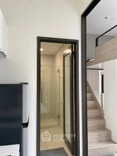 Modern compact apartment with sleek bathroom and loft-style stairs