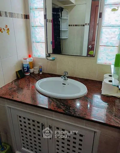 Elegant bathroom with granite countertop and modern sink in a stylish home.