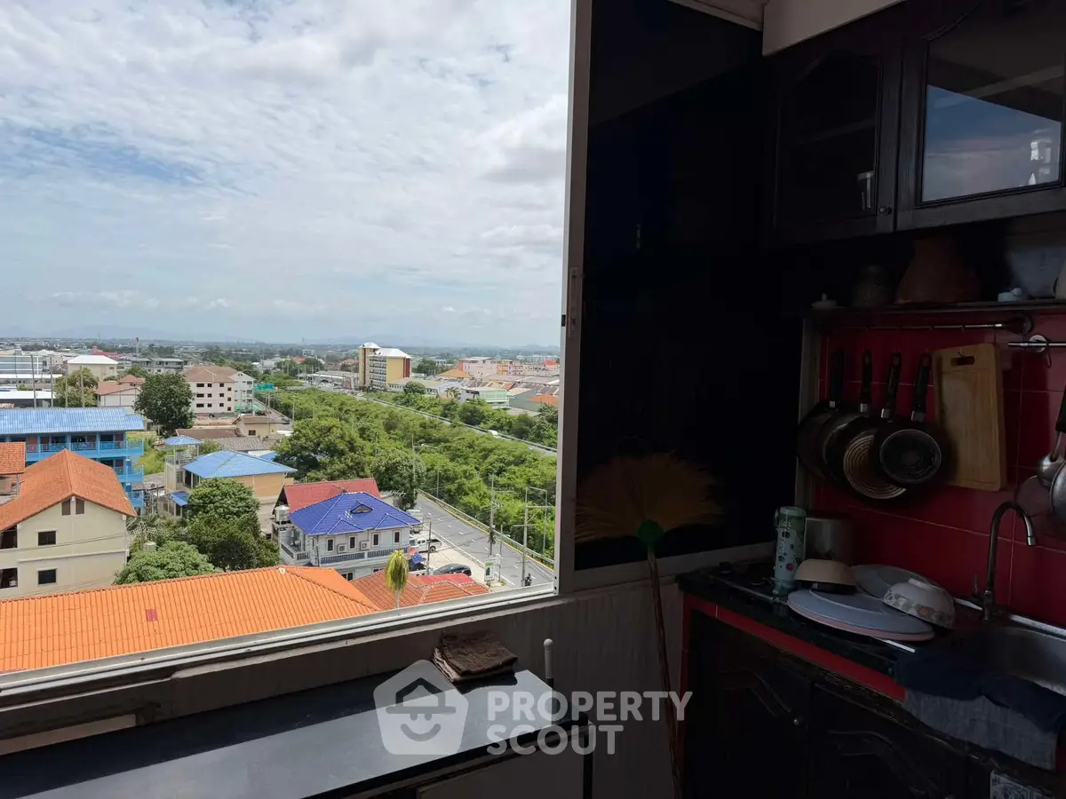 Spacious kitchen with a stunning city view, featuring modern cabinets and a sleek countertop.