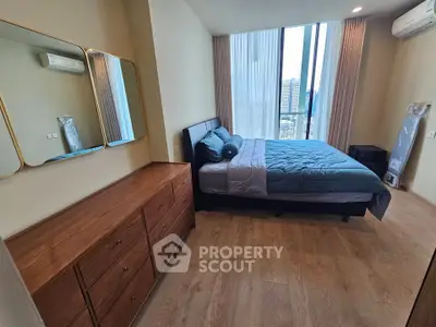 Modern bedroom with large windows and stylish decor in a high-rise apartment.