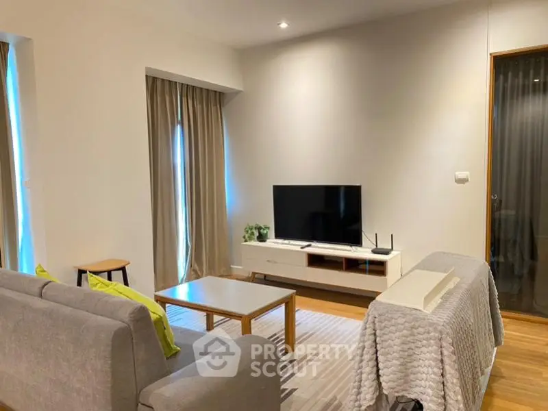 Modern living room with stylish furniture and large TV, perfect for relaxation.