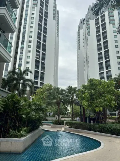 Luxurious high-rise residential towers with lush garden and pool view.