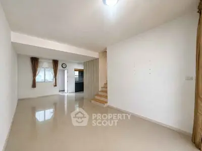 Spacious modern living room with open layout and staircase, ideal for contemporary living.