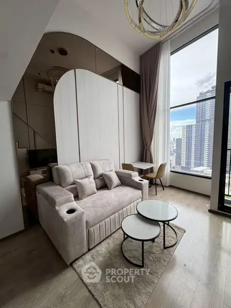 Modern living room with high ceiling and city view, featuring stylish furniture and large window.