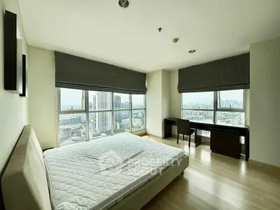 Spacious bedroom with panoramic city view and modern furnishings
