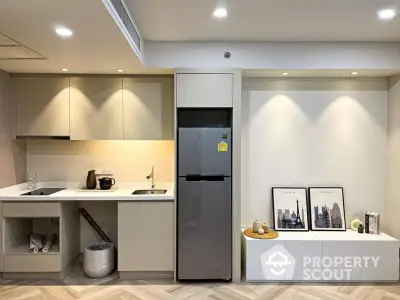 Modern kitchen with sleek cabinets and stainless steel fridge in stylish apartment.