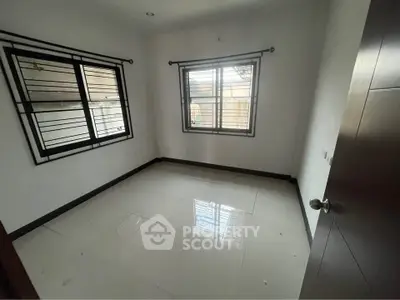 Spacious empty room with large windows and glossy tiled floor, perfect for customization.