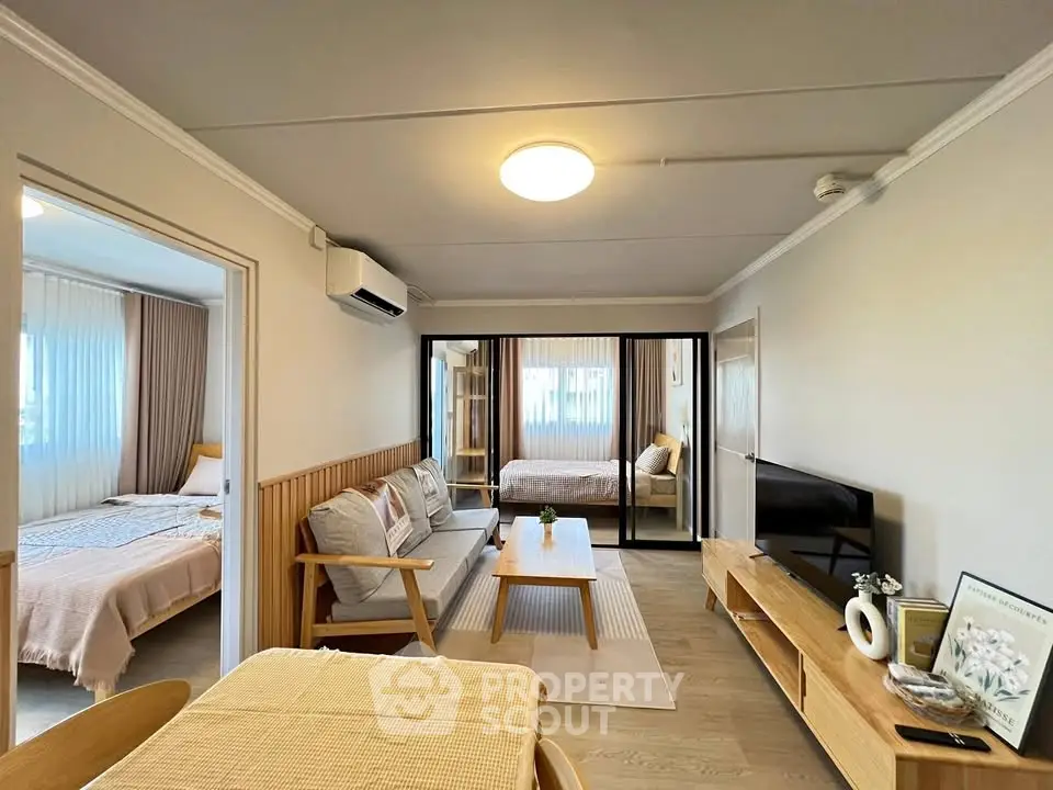 Spacious living room with modern decor and natural light in a cozy apartment.