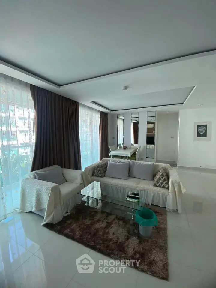 Spacious living room with modern decor and large windows in a luxury apartment.