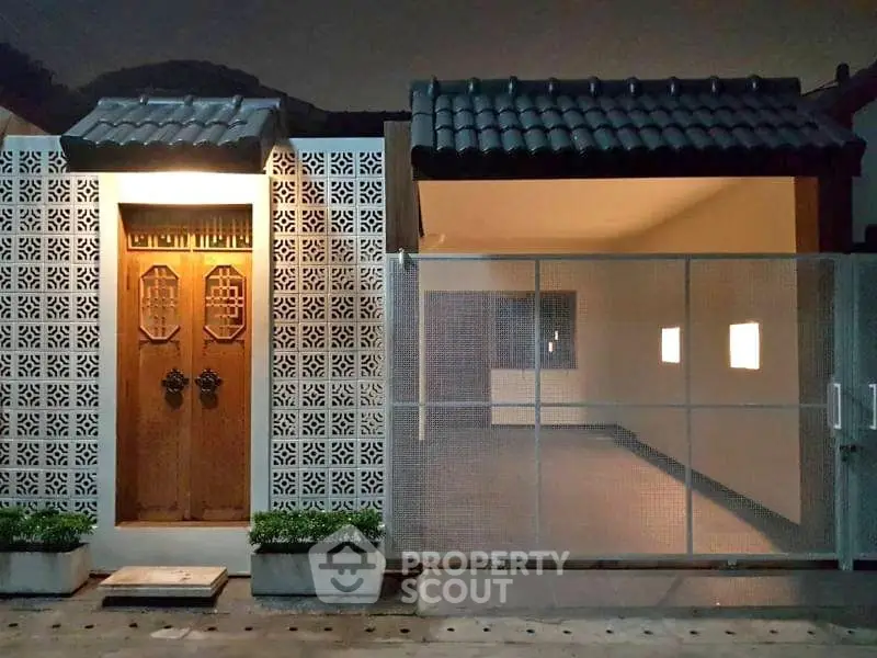 Charming exterior of a modern home with unique lattice design and gated entrance.