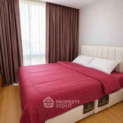 Cozy bedroom with elegant curtains and plush bedding in a modern apartment.