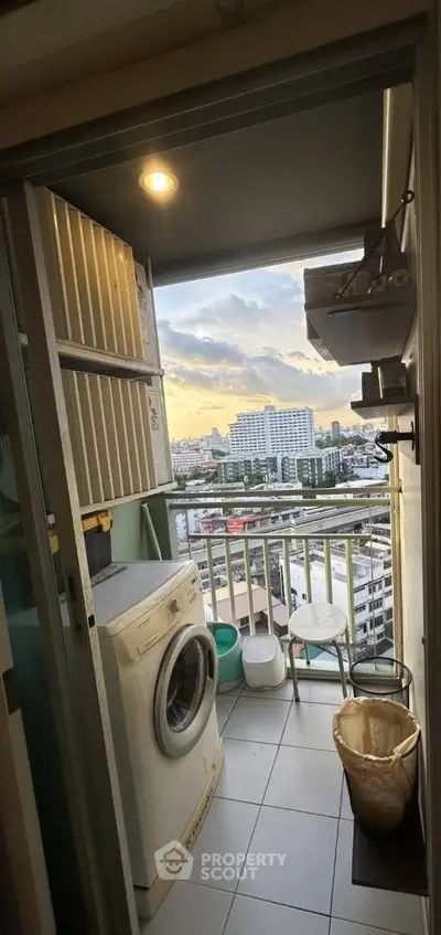 Charming balcony with city view and washing machine, perfect for urban living convenience.