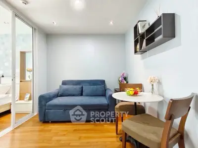 Cozy living room with blue sofa and dining area in modern apartment