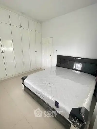 Spacious bedroom with sleek wardrobe and modern bed in a bright, minimalist design.
