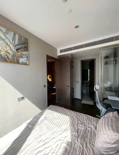 Modern bedroom with stylish decor and natural light, featuring a cozy bed and a study area.