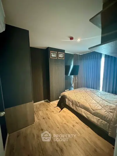 Modern bedroom with stylish decor and natural light, featuring a cozy bed and sleek flooring.