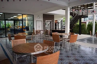 Stylish outdoor common area with modern seating and decorative flooring in a residential complex.