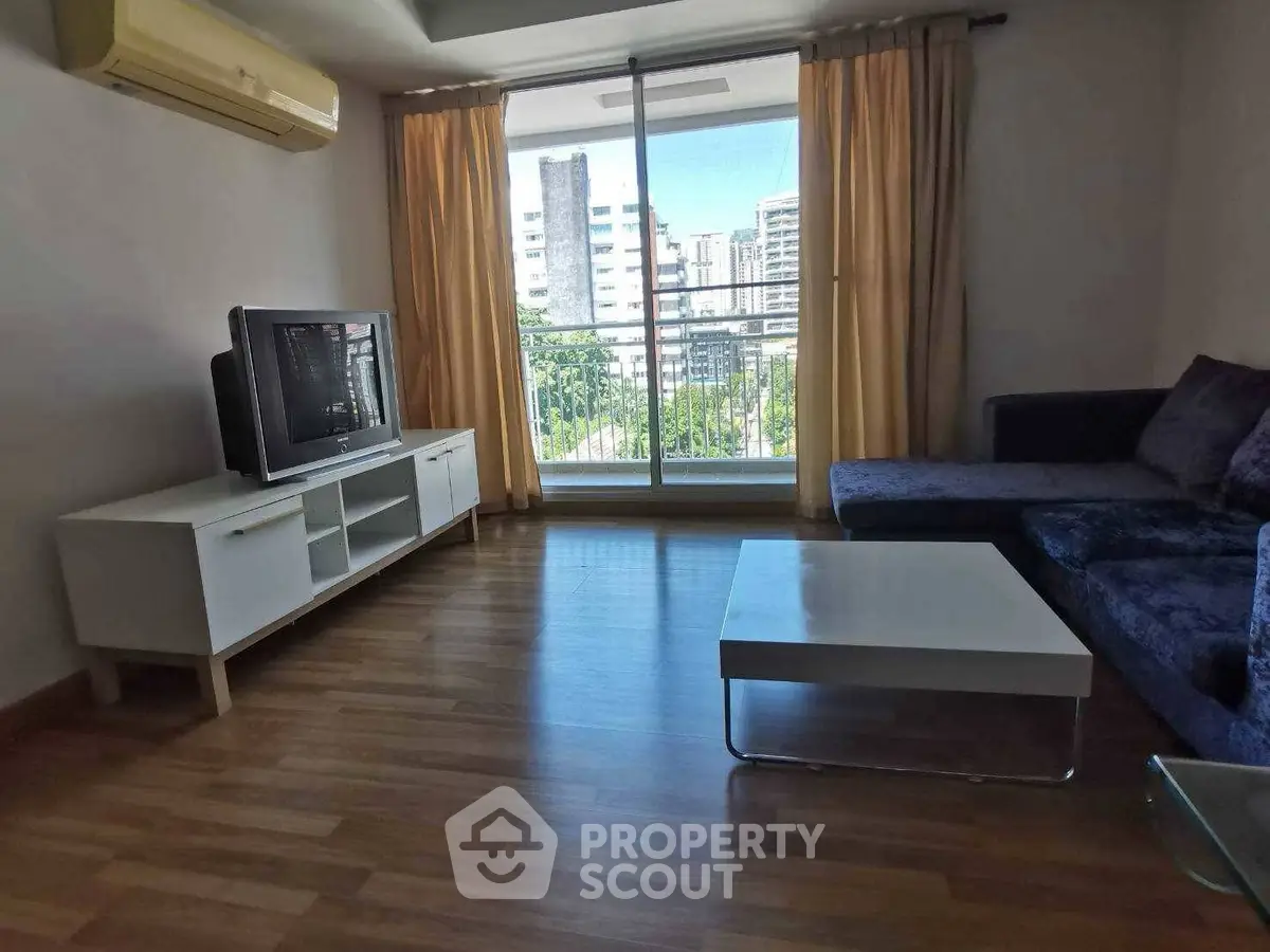 Spacious living room with modern furniture and balcony view in urban apartment.