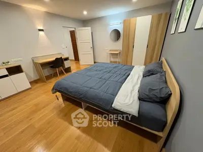 Modern bedroom with stylish furniture and wooden flooring