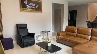 Elegant living room with leather sofa and armchair, modern decor, and stylish coffee table.