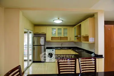 Modern kitchen with stainless steel appliances and washing machine