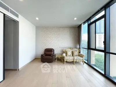 Spacious living room with elegant furniture and large windows offering city views.