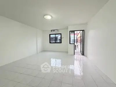 Spacious empty room with white tiled floor and large windows, perfect for customization.