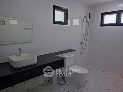 Modern minimalist bathroom with sleek fixtures and terrazzo flooring