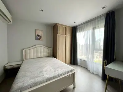 Bright and airy bedroom with city view, featuring elegant furniture and ample natural light.
