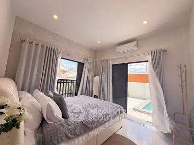 Luxurious bedroom with pool view, modern decor, and ample natural light.