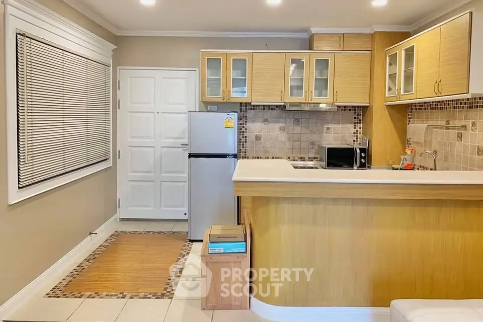 Modern kitchen with sleek cabinetry and stainless steel appliances in cozy apartment.