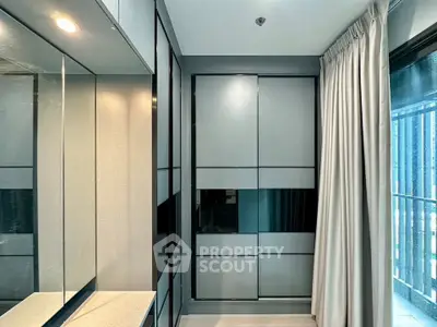 Modern bedroom with sleek wardrobe and large window for natural light