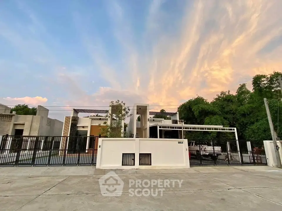 Modern architectural home with sleek design and stunning sunset backdrop.