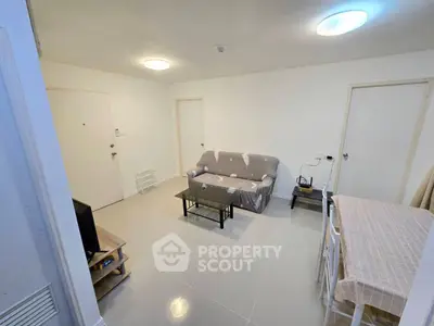 Spacious living room with modern furniture and tiled flooring, perfect for relaxation and entertainment.
