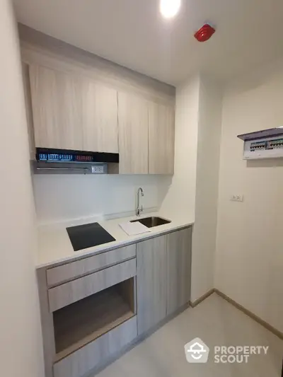 Modern compact kitchen with sleek cabinetry and electric stove