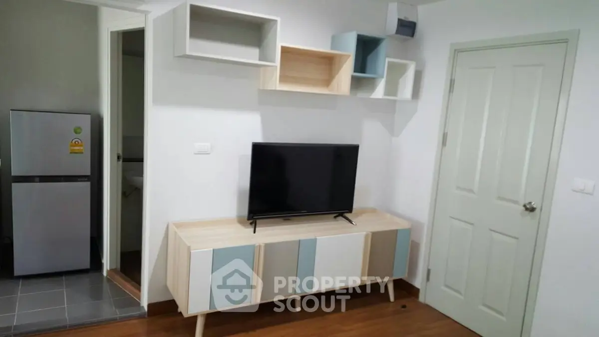 Modern living room with stylish TV stand and wall-mounted shelves in a cozy apartment.