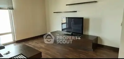 Modern living room with sleek TV stand and floating shelves, featuring hardwood floors and natural light.