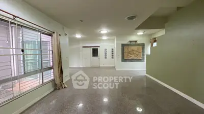 Spacious empty living room with large windows and tiled floor, ready for customization.