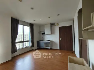 Spacious modern apartment with wooden flooring and large windows offering city views.
