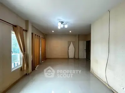 Spacious empty living room with large windows and neutral decor