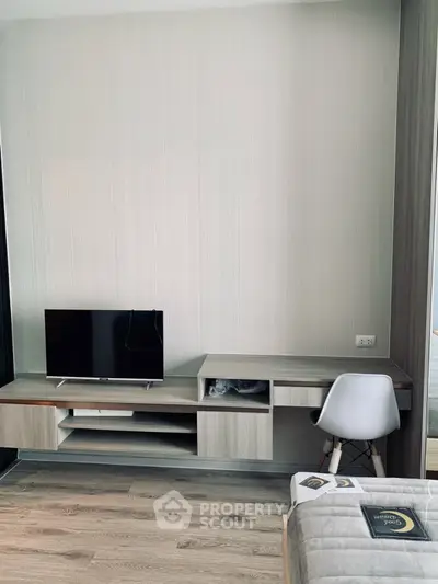 Modern bedroom with sleek TV stand and study desk, featuring minimalist design and neutral tones.