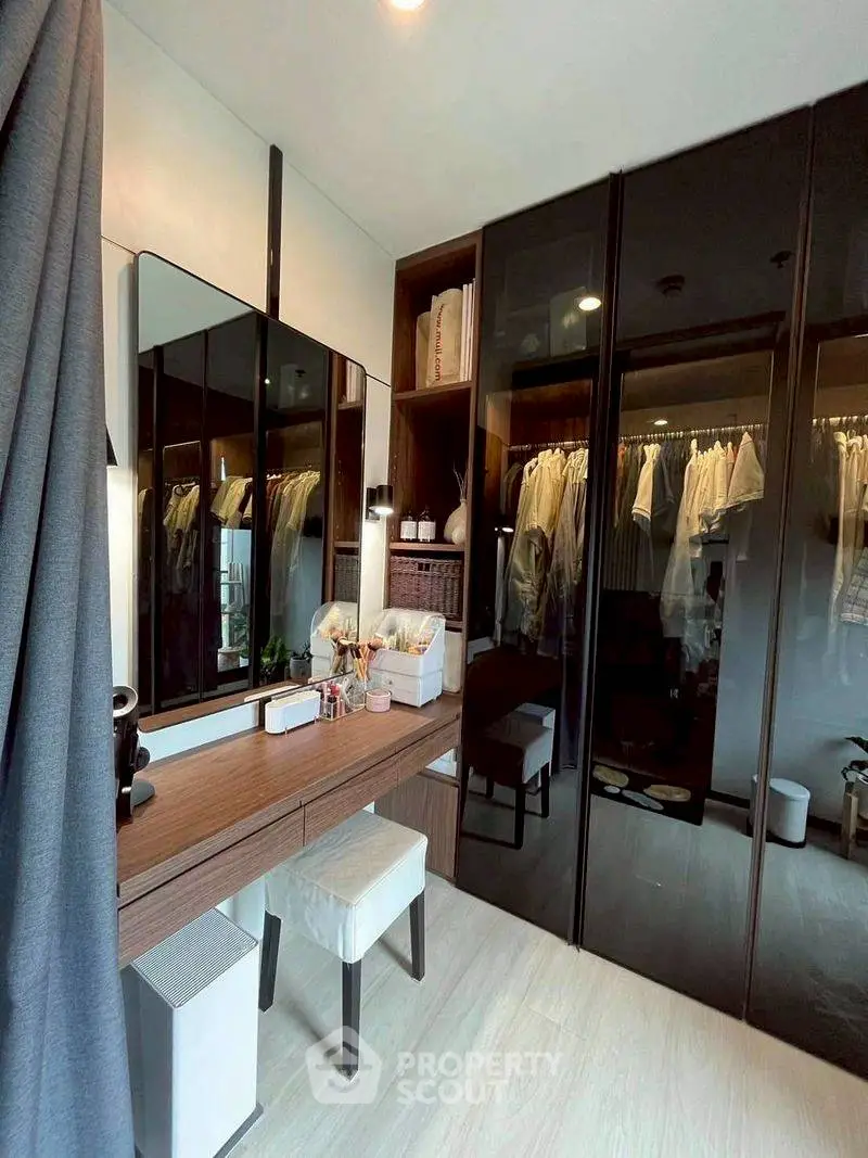 Stylish bedroom with modern walk-in closet and elegant vanity area.