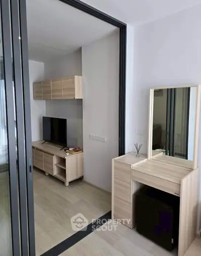 Modern living room with sleek wooden furniture and TV, perfect for cozy urban living.